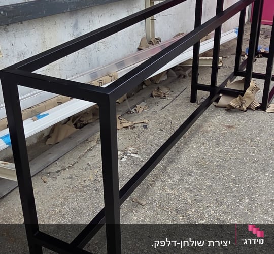 מסגרת מתכת שחורה על רקע קיר חיצוני